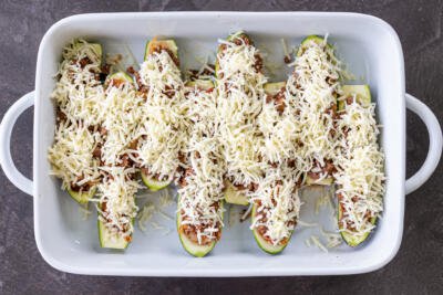 Stuffed zucchini boats with cheese in a baking pan