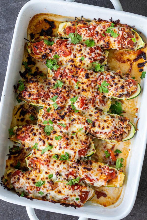 Stuffed Zucchini Boats in a baking dish with herbs