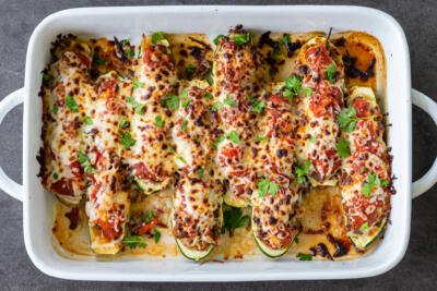 Stuffed Zucchini Boats in a baking dish with herbs