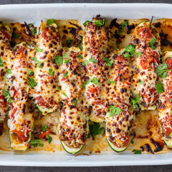 Stuffed Zucchini Boats in a baking dish with herbs