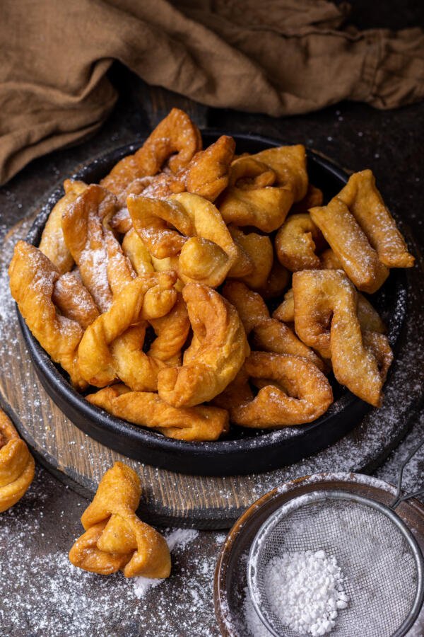 bowl of angel wings in a bowl with powder sugar