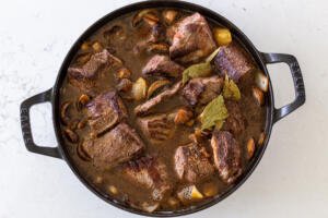 beef with broth and seasoning in a pan