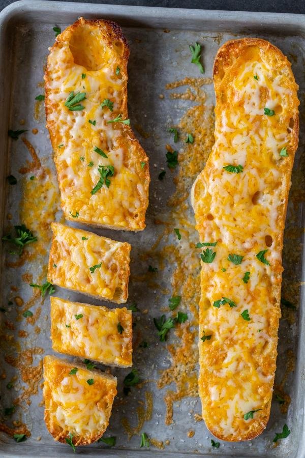Sliced Bread with melted cheese on a baking pan