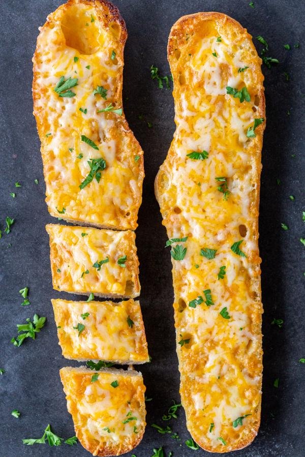 Sliced Bread with melted cheese on a baking pan 