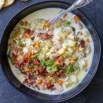 Clam Chowder in a bowl with bacon and herbs.