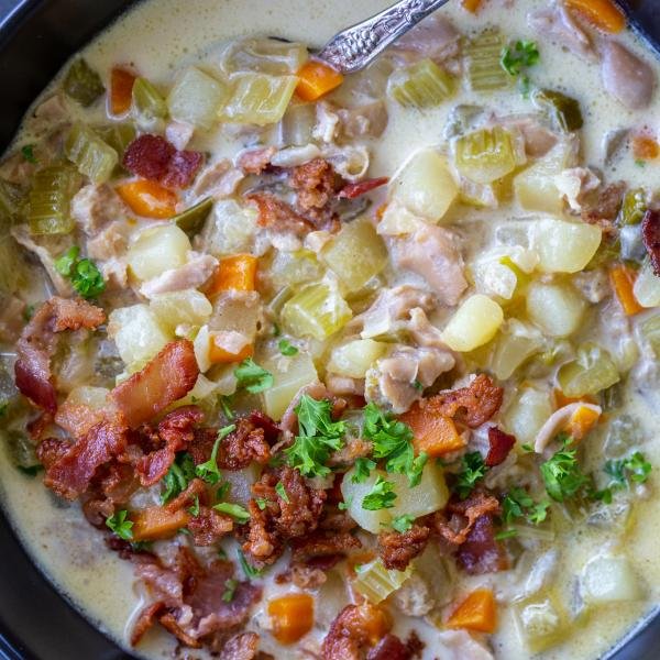 Clam Chowder in a bowl with bacon and herbs.