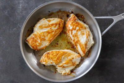 Chicken breast browning in a pan.