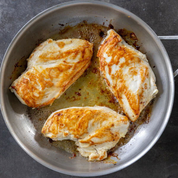 Chicken breast browning in a pan.