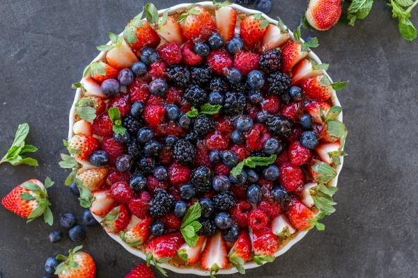 Fruit tart with berries around it