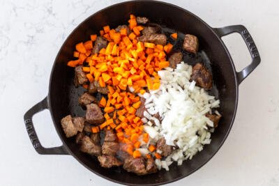 beef, carrots and onions in a pan