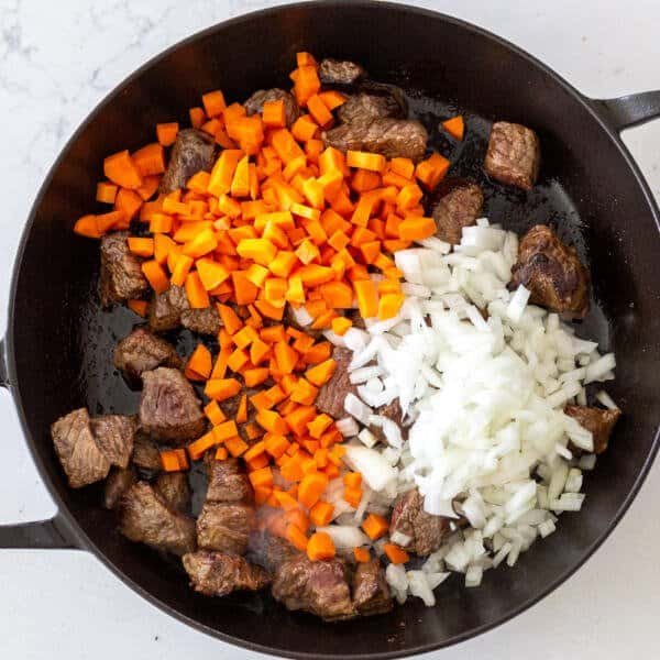 beef, carrots and onions in a pan