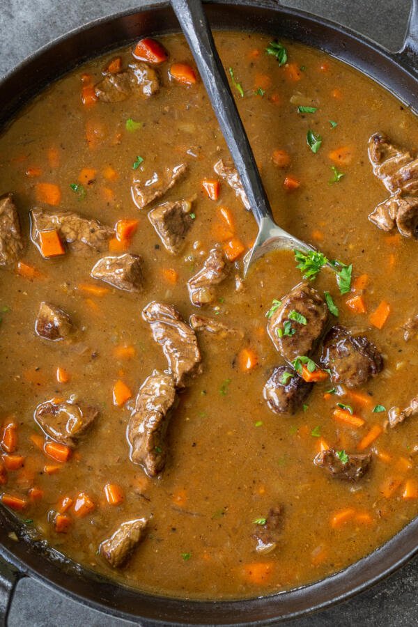 beef stew gravy in a pan with a spoon