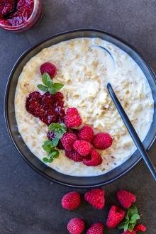 Old-Fashioned Rice Pudding in a bowl with berries and jam