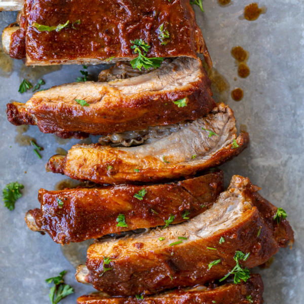 Baked BBQ ribs with herbs on a pan.
