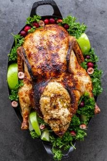 Roasted duck on a serving tray with greens