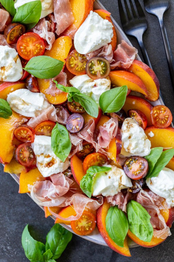 Tomato peach burrata salad on a plate