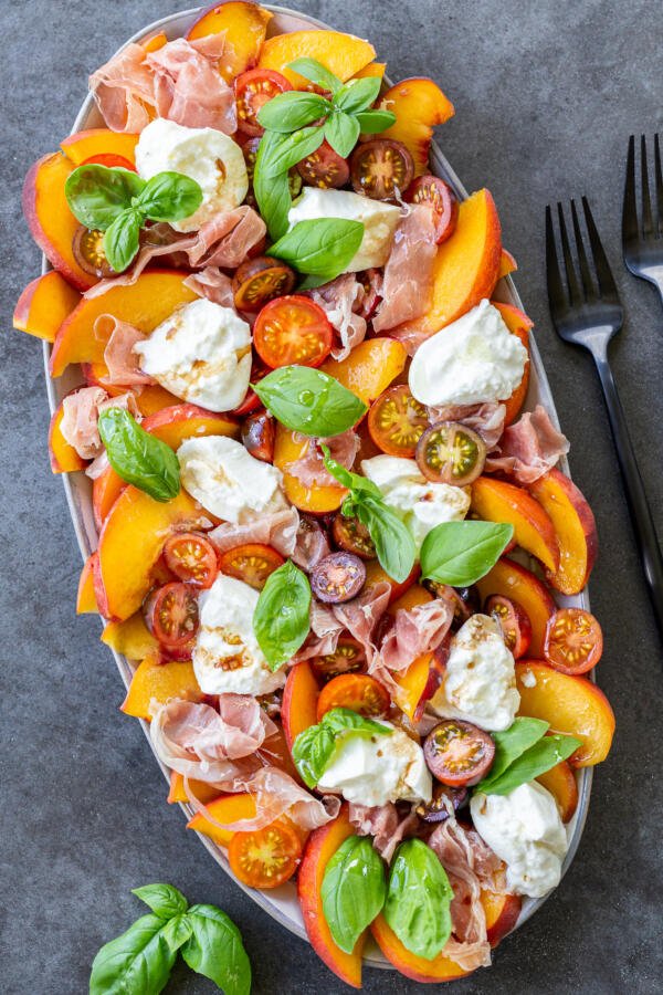 Tomato peach burrata salad on a plate