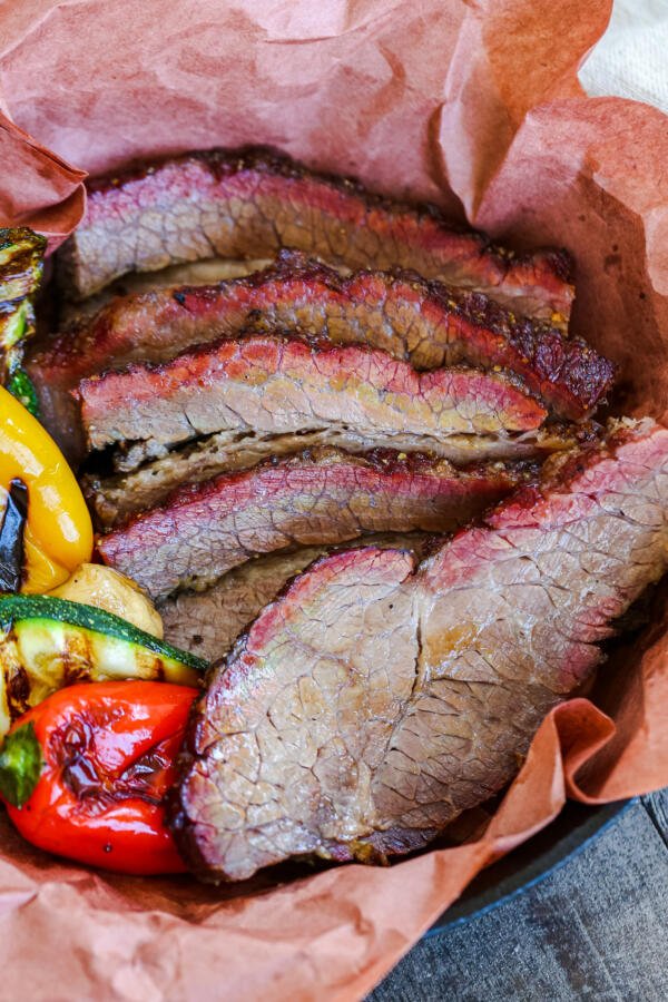 Beef brisket in a tray with paper.