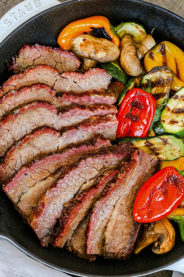 Beef brisket with veggies on a tray. 