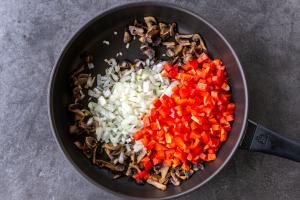 Mushrooms, onion and bell peppers in a pan