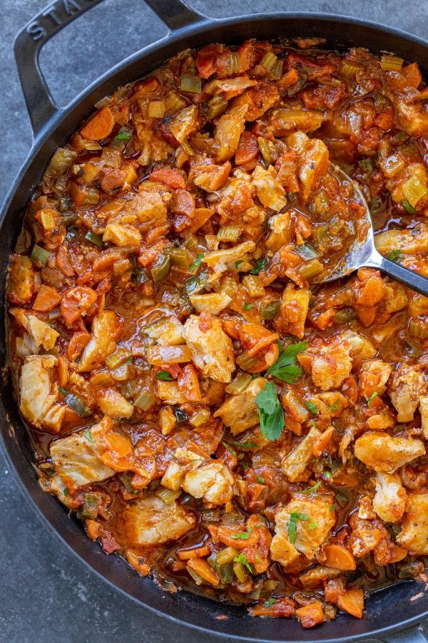 Baked cod with veggies in a pan with a spoon