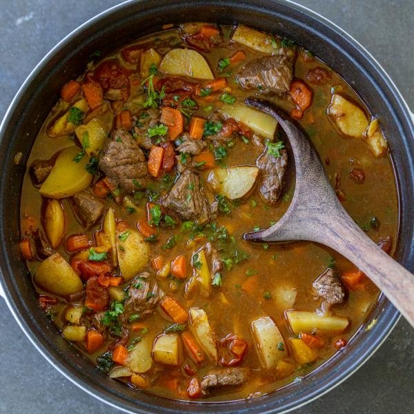 Pot of shurpa soup with a spoon.