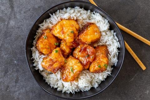 Sweet and sour chicken in a pan with rice