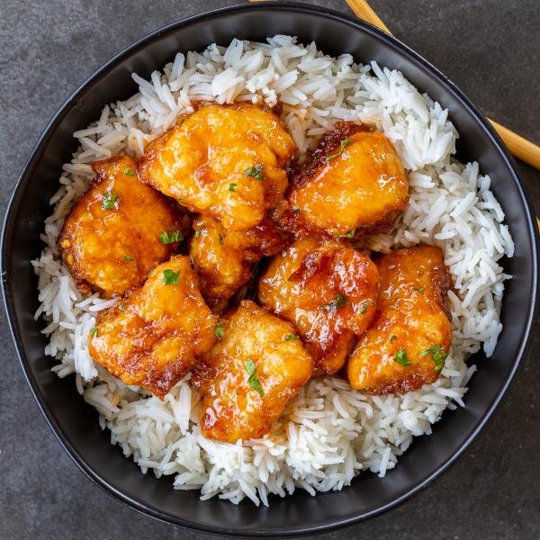 Sweet and sour chicken in a pan with rice