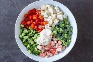All the Broccoli Crab Salad ingredients in a bowl with mayo dressing