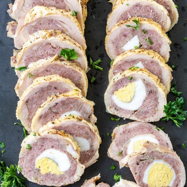 Chicken Roulade on a serving tray with herbs