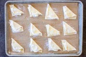 Sweet Cheese Turnovers on a baking pan with sugar