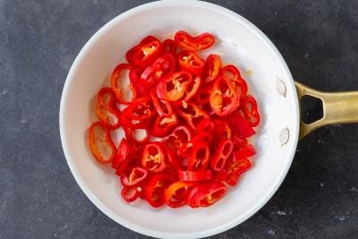 Bell peppers cooking in a pan.