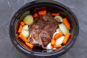 Beef roast with veggies in a slow cooker.