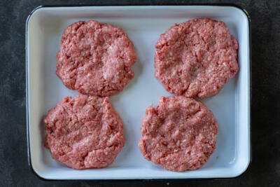 formed beef burger patties on a pan.