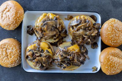 Burgers topped with mushrooms and onion mixture.