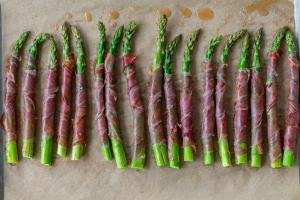 Asparagus Wrapped in Prosciutto baked on a baking sheet
