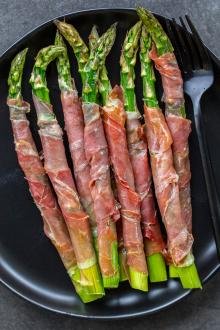 Baked Asparagus Wrapped in Prosciutto on a serving tray