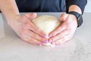 Hands holding the dough to shape