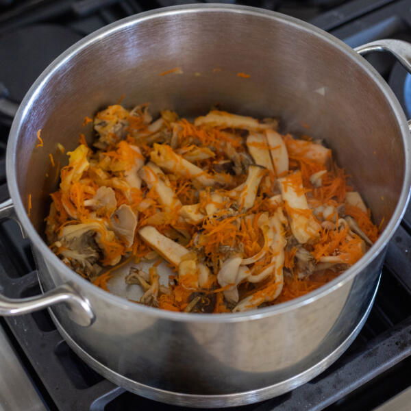 Mushroom, carrots and onion in a pot.