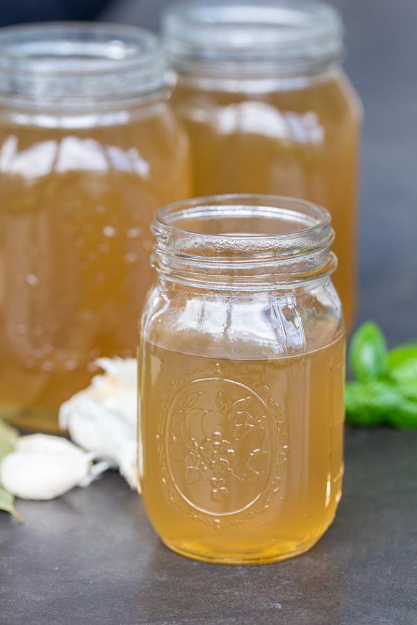 Bone Broth in jars with hers next to it. 