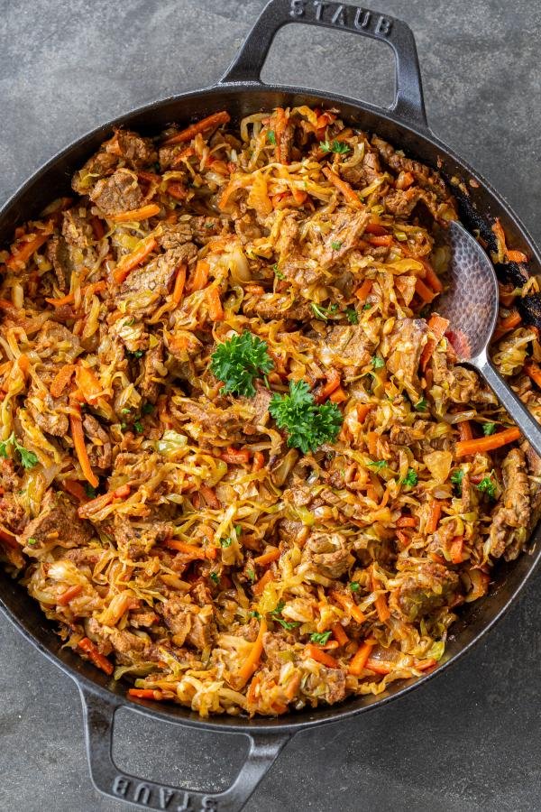 Braised Cabbage with Beef in a pan with spoon