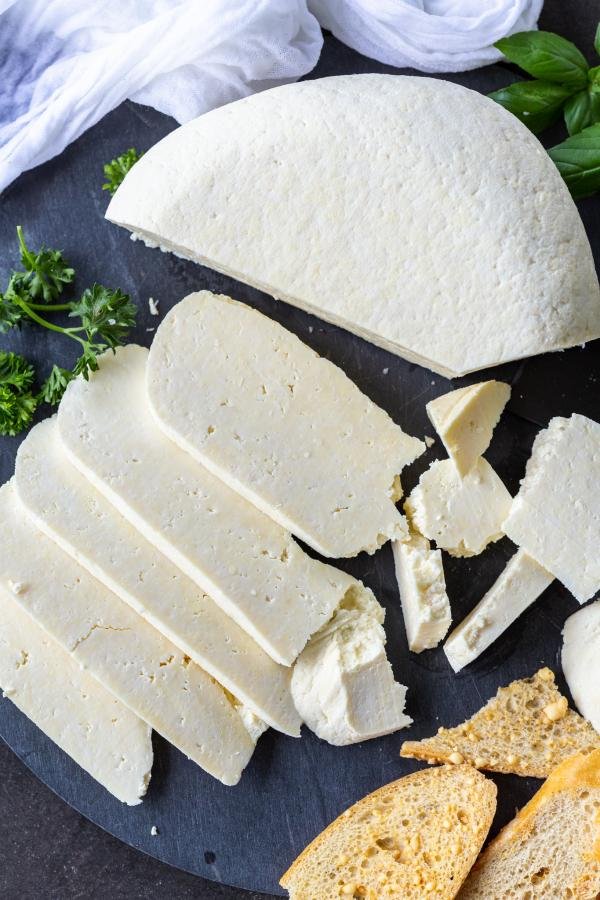 Sliced homemade cheese on a serving tray.