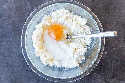 Cheese, sugar and egg in a bowl.