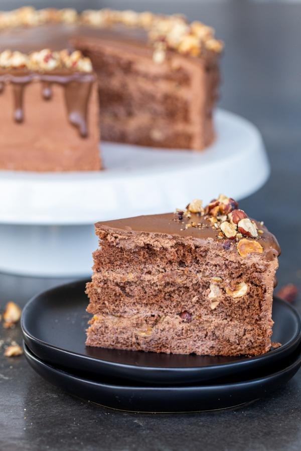 Chocolate Hazelnut Cake cut a slice out of a cake on a stand. 