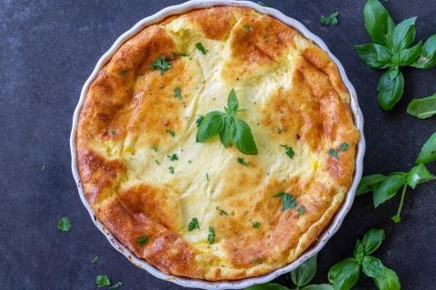 Crustless Quiche in a pan with herbs around it.