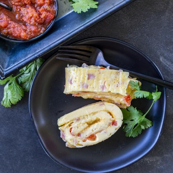 Egg Omelette Roll on a plate with a fork and salsa for dipping
