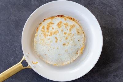 tortillas with cheese and meat in a pan