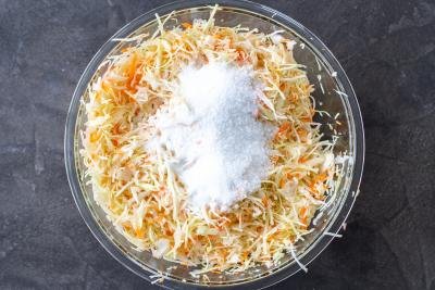 Carrots, cabbage, sugar and salt in a bowl
