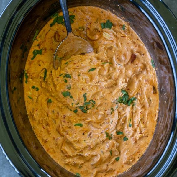 Mexican Crock Pot Chicken in a crock pot with a spoon.