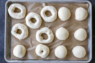 Bagels shaped on a baking sheet.